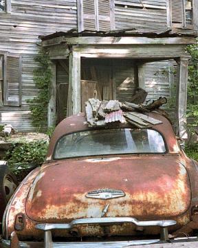 Rusty Car in Front of House